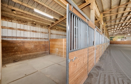 Barn Interior Interior barn with horse stalls beside the sand arena